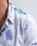 Close-up of a white shirt with colorful abstract patterns on a plain background