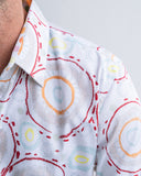 Close-up of a shirt with colourful circular patterns on a white background