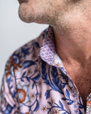 Close-up of a person wearing a patterned shirt with a neutral background