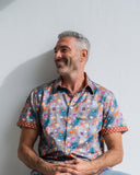 Man wearing a colourful patterned shirt against a plain background