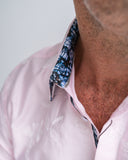 Close-up of a man wearing a pink floral shirt with floral collar.