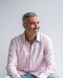 Man wearing a pink shirt with a white background